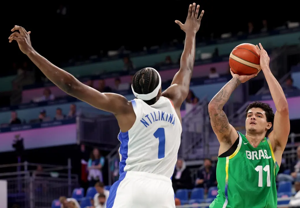 El brasile&ntilde;o Gui Santos (d) trata e lanzar pesar a la defensa del franc&eacute;s Frank Ntilikina en el debut de Francia y Brasil en el Pierre Mauroy Stadium en Villeneuve-d'Ascq, Francia. EFE/EPA/ALEX PLAVEVSKI