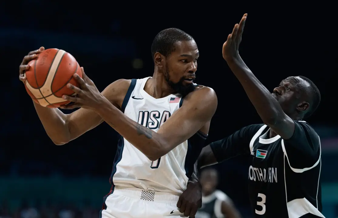 El estadounidense Kevin Durant (i), que busca un in&eacute;dito cuarto oro ol&iacute;mpico, ante Majok Deng, durante el partido que enfrent&oacute; a su equipo con Sud&aacute;n del Sur en la fase previa del torneo de baloncesto de los Juegos de Par&iacute;s 2024 en el estadio Pierre Mauroy de Villeneuve-d'Ascq. EFE/EPA/ALEX PLAVEVSKI