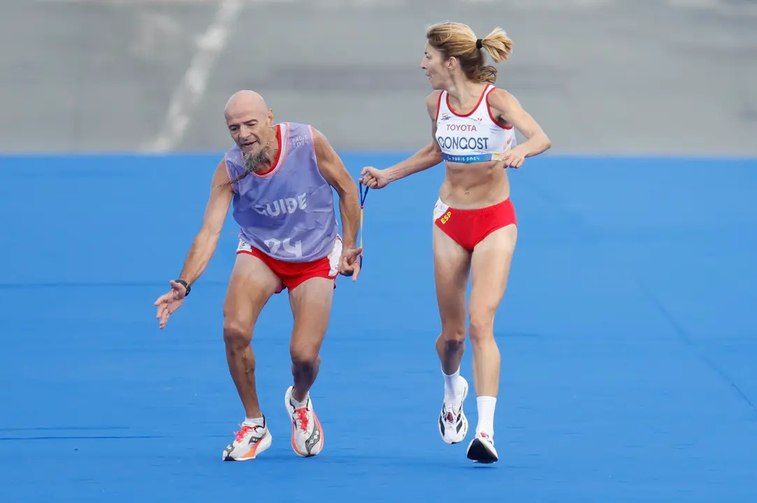 La atleta espa&ntilde;ola Elena Congost, medalla de bronce en la final de la marat&oacute;n T12 femenino, ayuda a su gu&iacute;a, que llega exhausto a la l&iacute;nea de meta, este domingo en los Juegos Paral&iacute;mpicos de Par&iacute;s 2024. EFE/ Javier Etxezarreta