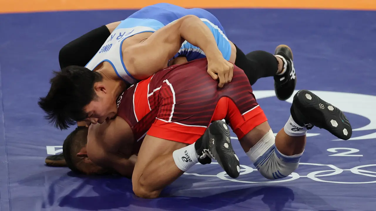 El luchador venezolano Jose Rodriguez Orozo Raiber (rojo) en su combate ante el norcoreano Ri se Ung (azul) en su combate por la medalla de bronce de Lucha Grecorromana, 60 kg, de los Juegos Ol&iacute;mpicos Par&iacute;s 2024, en la capital gala. EFE/ Miguel Guti&eacute;rrez